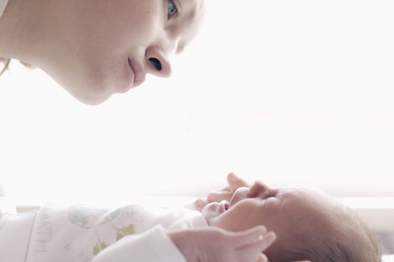 baby crying - mother comforting crying baby wondering what's wrong