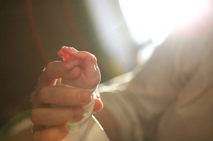 Dad and baby - Dad touching baby's hand with finger. Dad and baby bonding