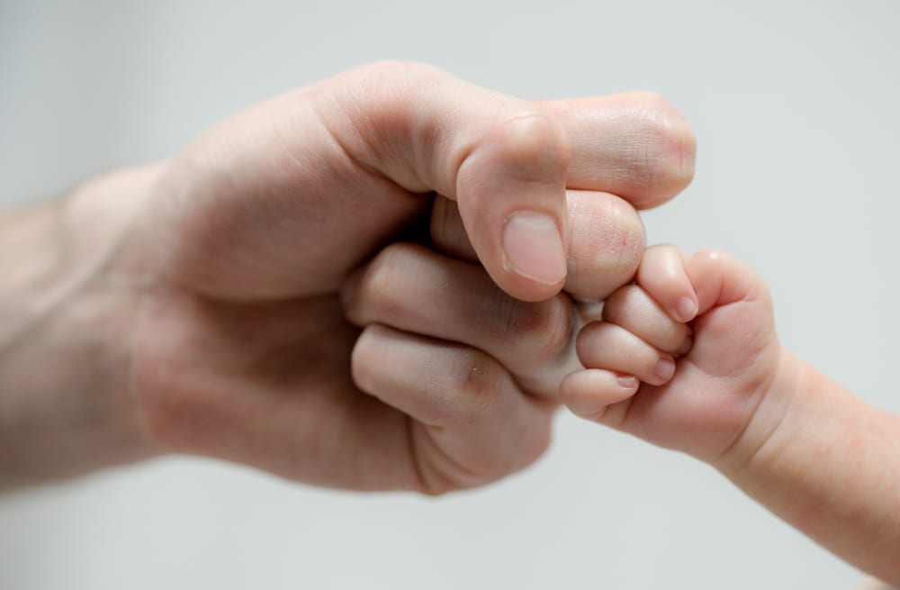 Dad and baby - Dad and baby touching knuckles symbolising dad and baby bonding