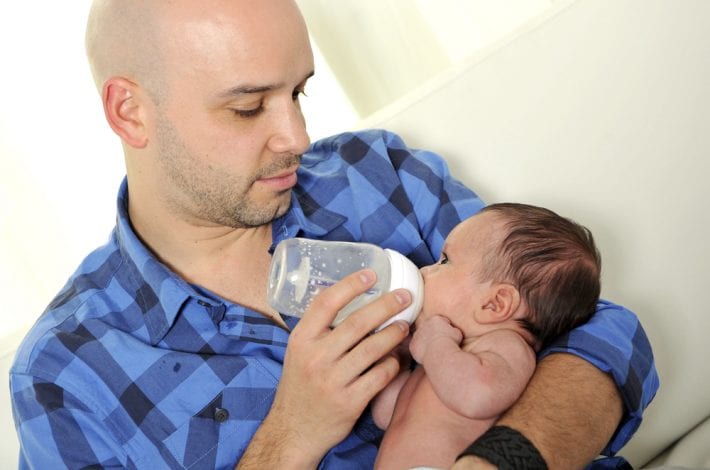 Dad and baby - Dad bottle feeding newborn baby. Dad and baby bonding