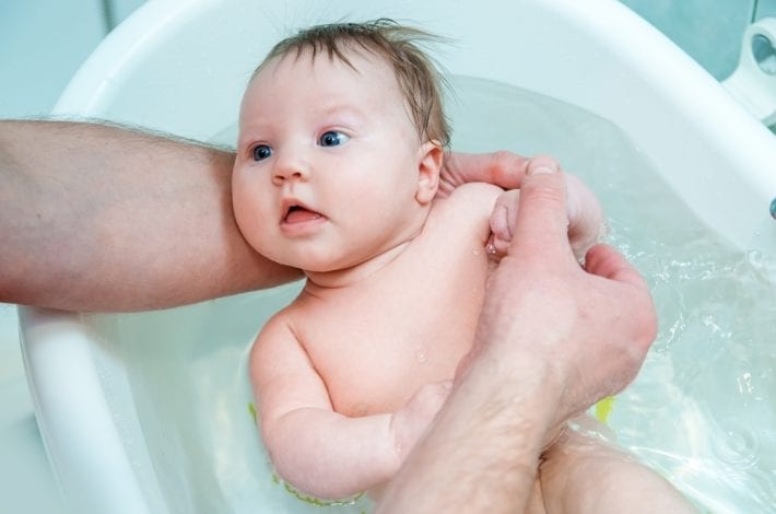 Dad and baby - Dad giving newborn baby a bath. Dad and baby bonding