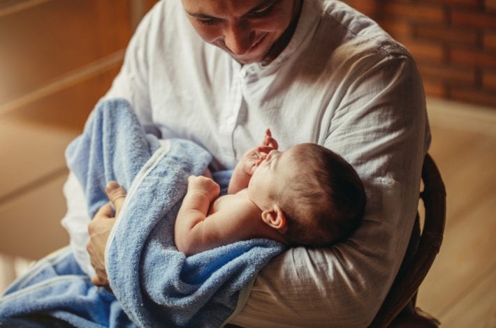 Dad and baby - Dad rocking baby, smiling. Dad and baby bonding