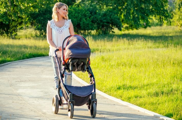 Tips for new mums - new mum walking in the park with newborn baby in pram. tips for new mums