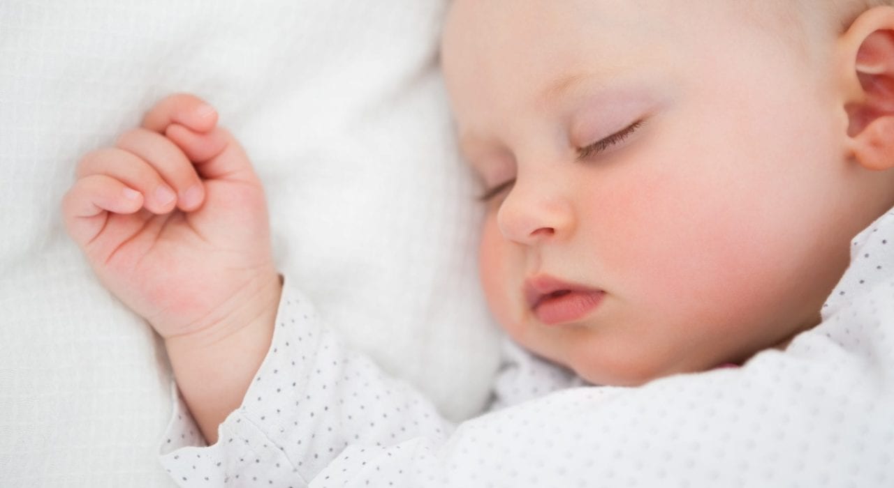 newborn baby fast asleep showing face and hand