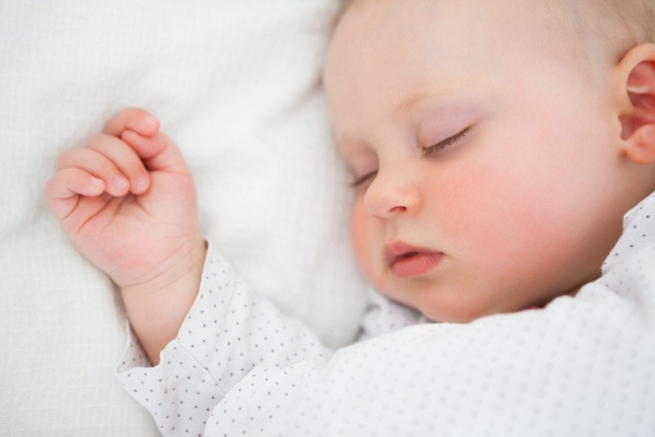 newborn baby fast asleep showing face and hand