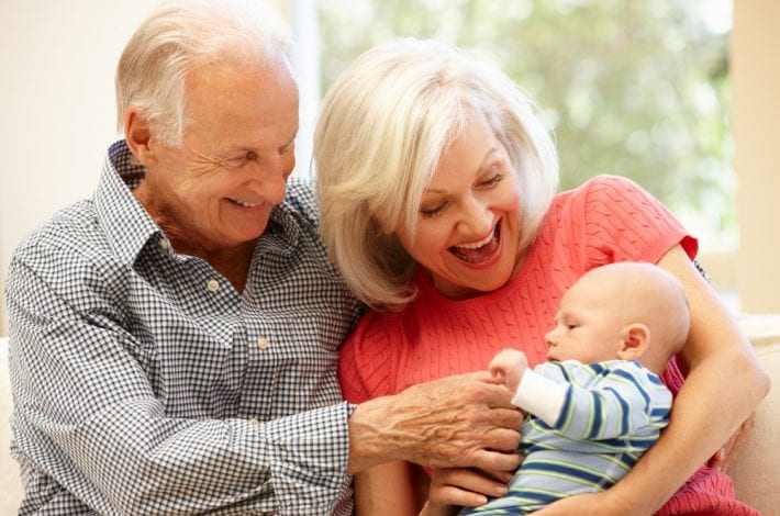 newborn - grandparents smiling at newborn baby grandson giving mum a break