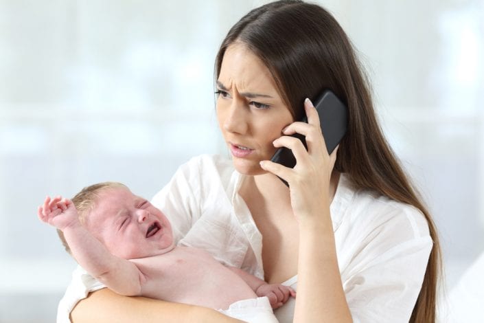 baby crying - mother calling for help holding baby crying