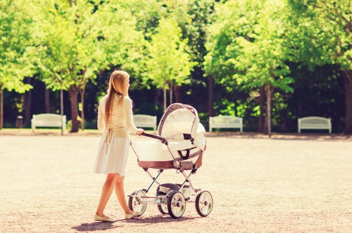 mother walking in the park with her newborn baby in a pram