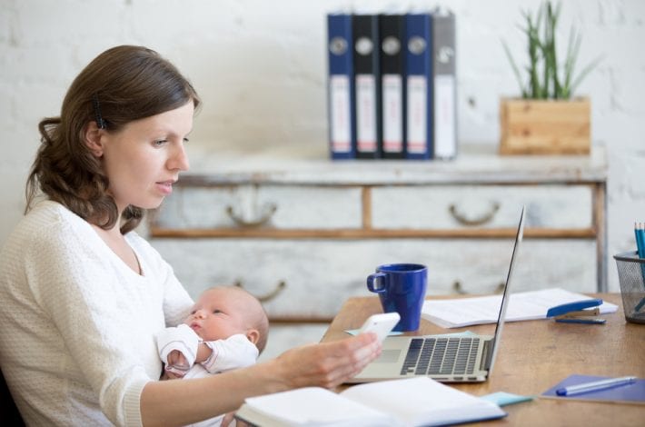 newborn - new mother working at computer with phone and coffee