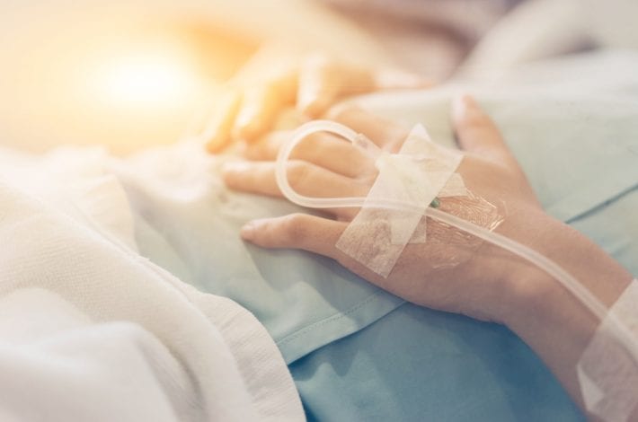 newborn - new mum's hands with drip recovering from birth in hospital