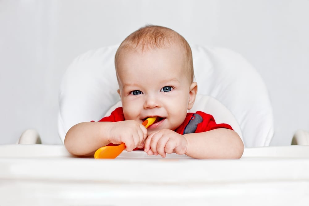 weaning - first foods - early weaning - wean baby - baby holding spoon and smiling