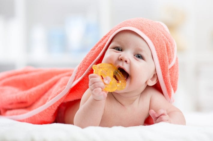 baby teething with teething toy in his mouth