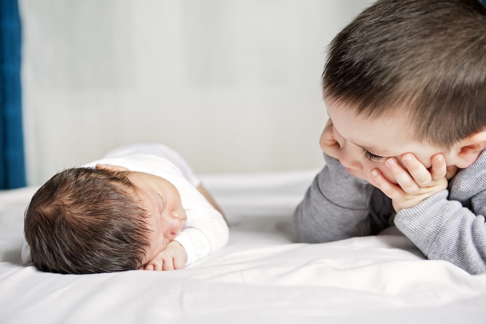 brother looking at baby sibling theme of sibling jealousy