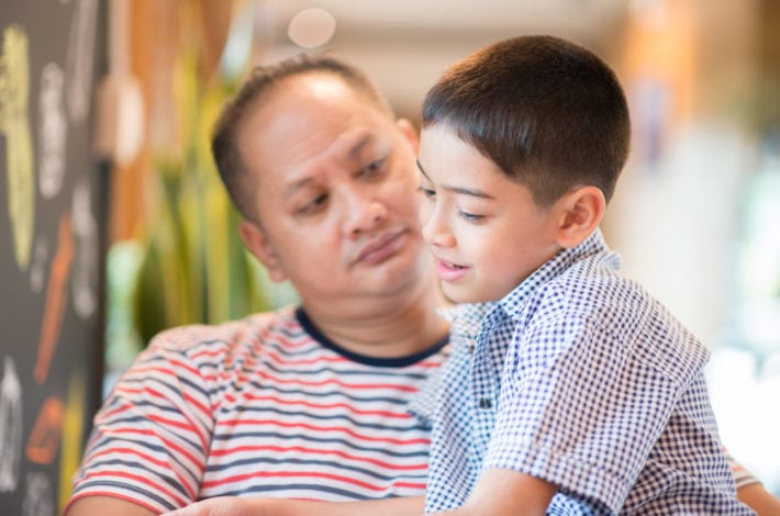 father and son sitting and talking together. Father listening