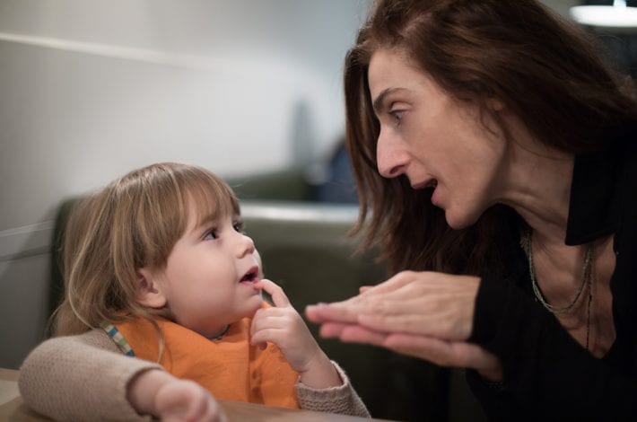 mother explaining to toddler daughter