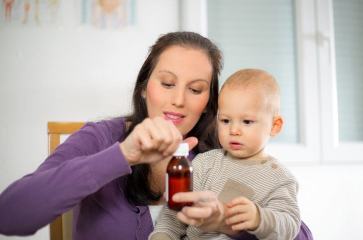 mother giving baby teething medicine