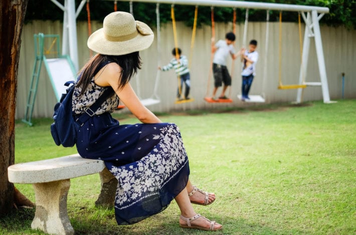 mother watching her sons doing risky things on the swing