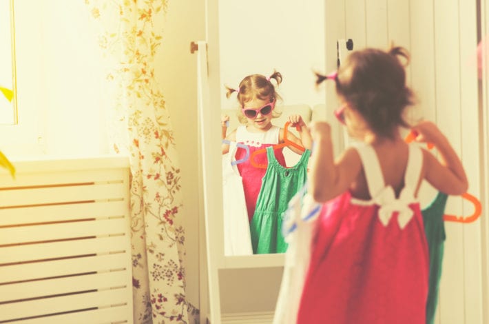 toddler choosing between two dresses