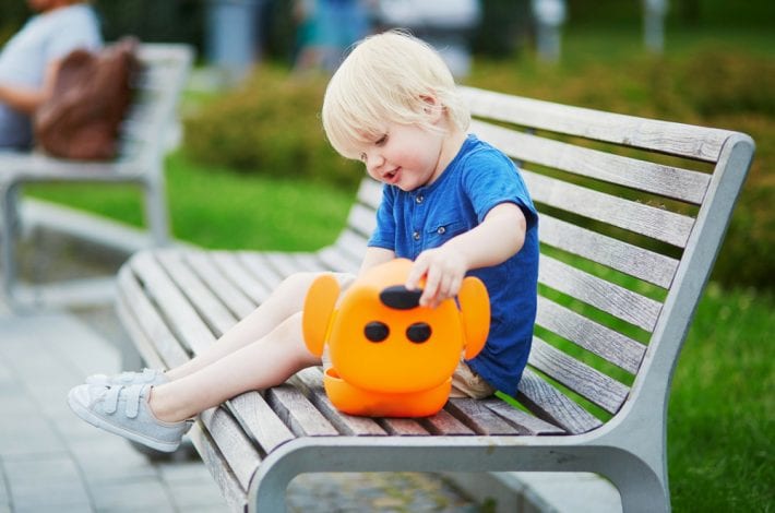 toddler having snack on park bench