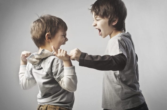 two children fighting showing aggressive behaviour
