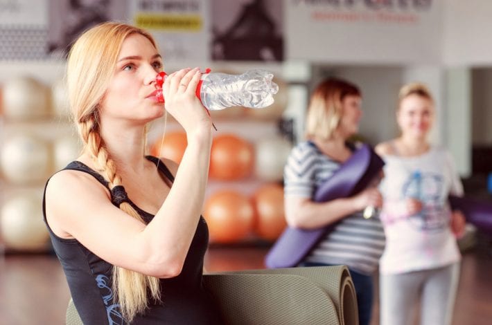 exercising during pregnancy - tips for staying safe -pregnant woman drinking water after a class